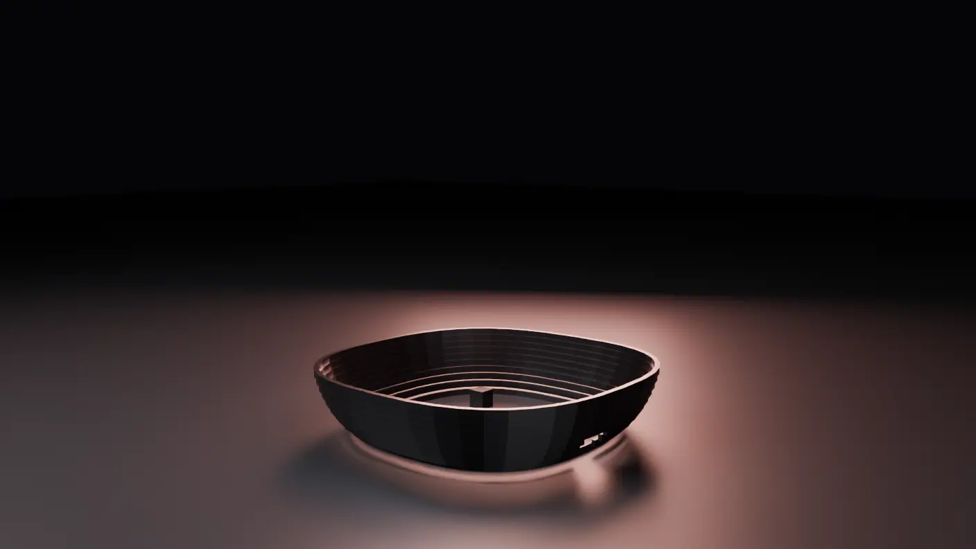 An empty, softly lit floor in a dark room. A low metal frame has landed on it, with a shallow plinth across the back holding a single boxy power supply seated beside the floor intake.